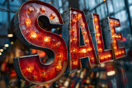 Brightly lit vintage sign displaying the word 'SALE' in bold letters.