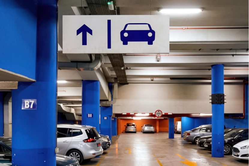 Directional sign in a parking garage indicating the way to the parking area.