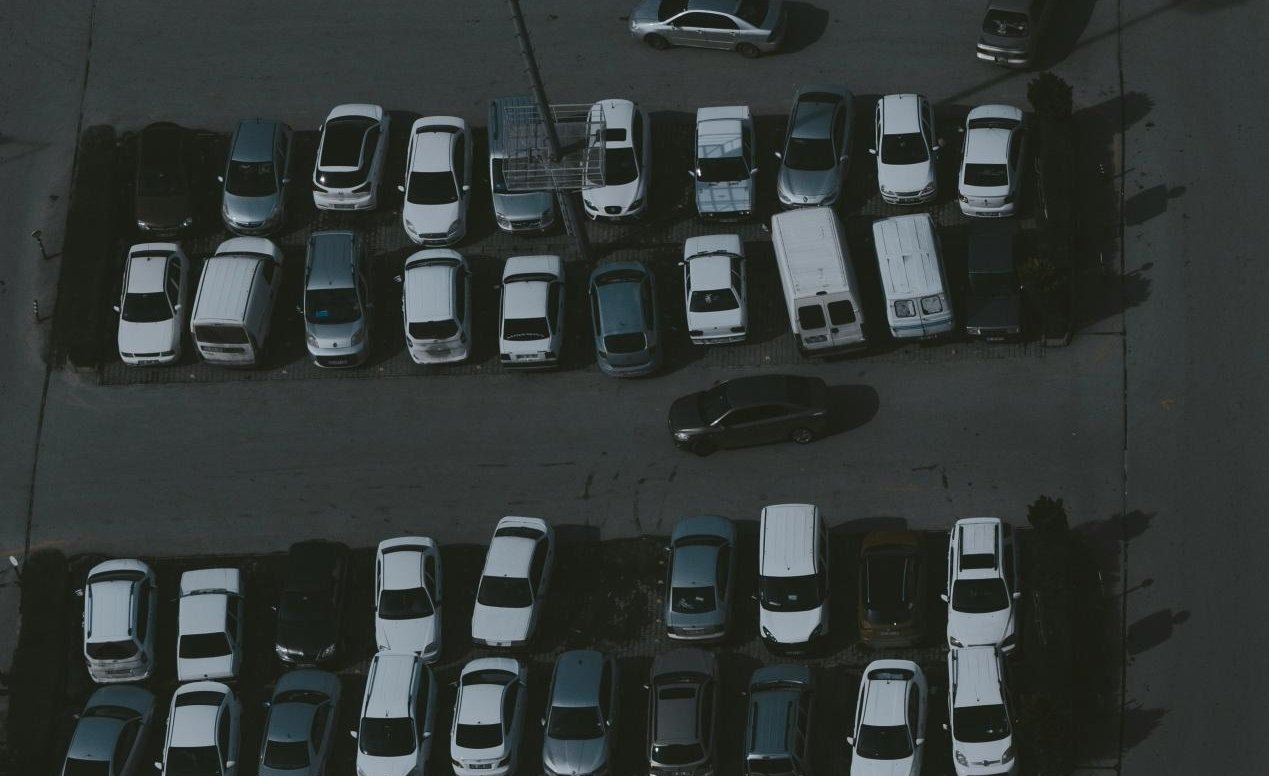 Off-site airport parking lot with several cars parked.