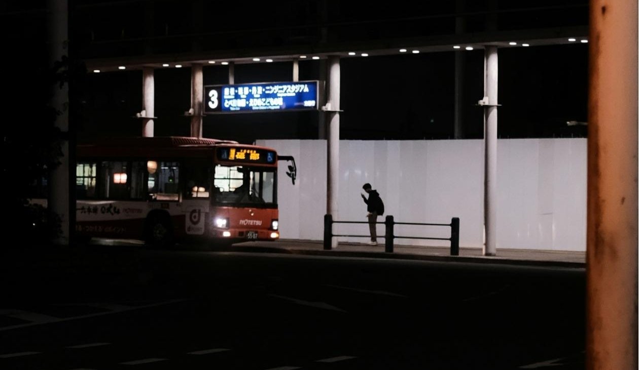 Person waiting for bus at night